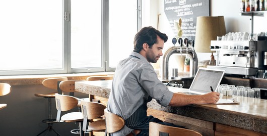 How To Optimise Your Hospitality Budget With Dext - cafe owner working on his finances